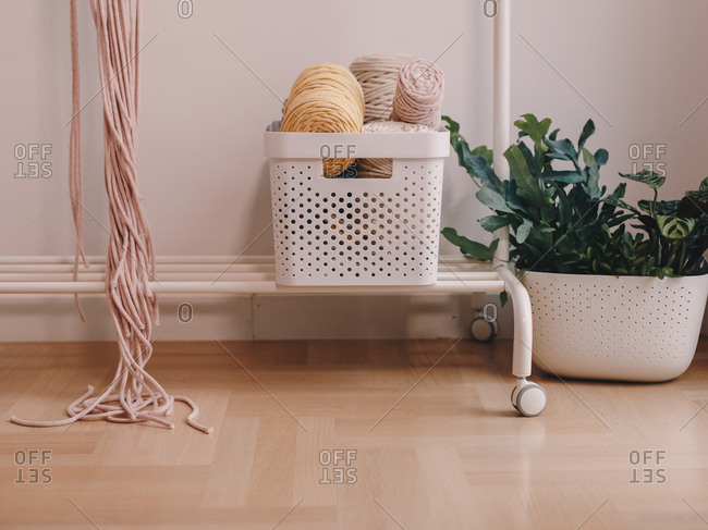 Basket full of yarn balls and other sewing equipment.