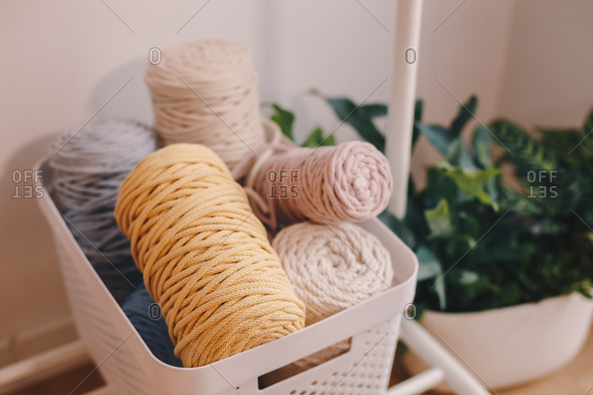 Basket full of yarn balls and other sewing equipment.