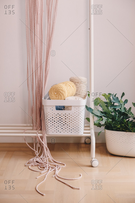 Basket full of yarn balls and other sewing equipment.