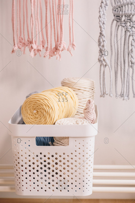 Basket full of yarn clews and other materials used for sewing.