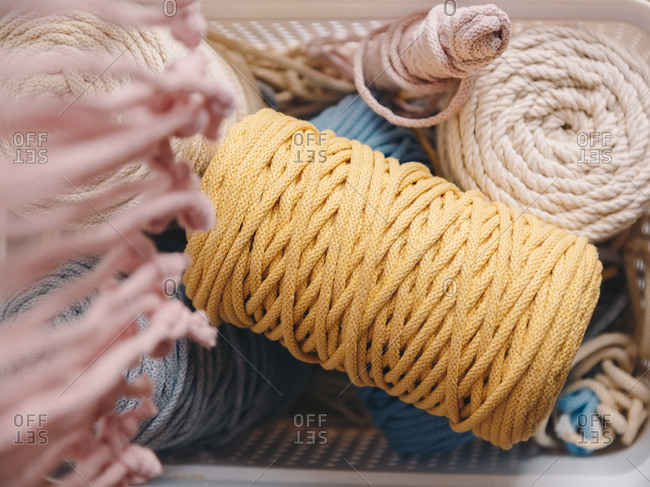 Basket full of yarn clews and other materials used for sewing.
