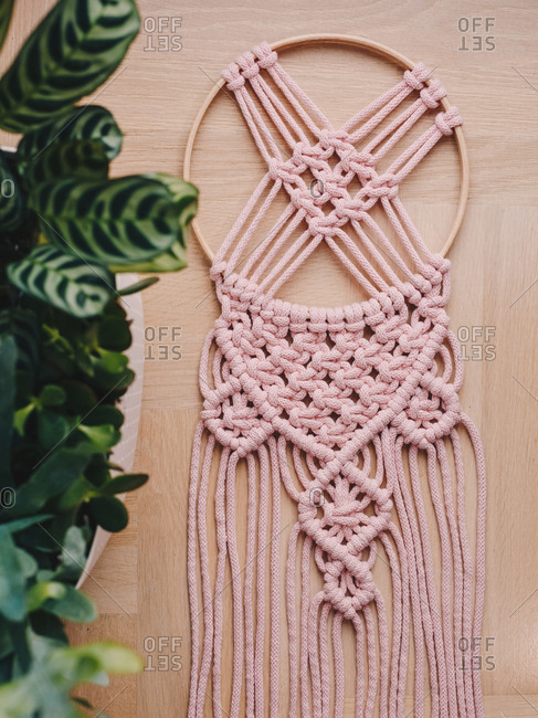 Pink macrame decor on a dream catcher.