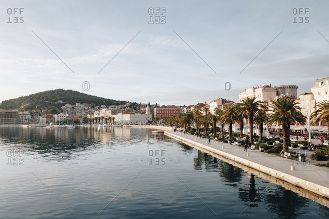 Beautiful scenic view of riva, a famous seaside promenade in the center of Split, Croatia, during daylight. Marjan hill is visible in the distance.