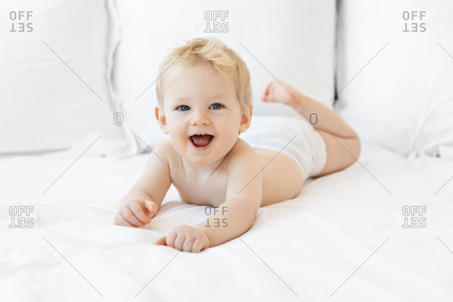 Adorable blonde 2 year old laughing during tummy time