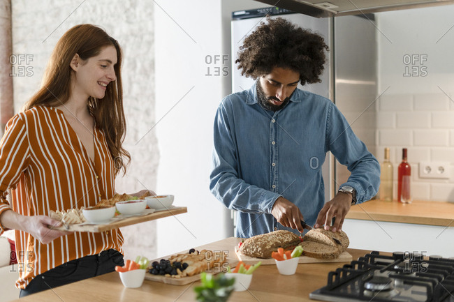 Couple standing in kitchen- preparing dinner party
