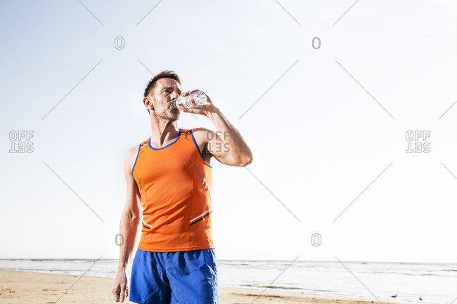 Man Drinking from Thermos on Beach - Stock Photo - Masterfile -  Rights-Managed, Artist: Masterfile, Code: 700-00606349