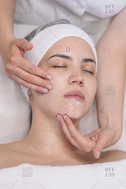 Cosmetician doing face treatment to client