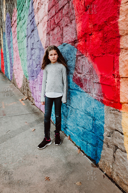 Girl standing against a colorful mural