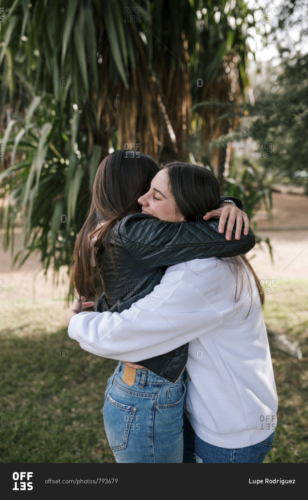 Young couple of lesbians hugging each other in a park