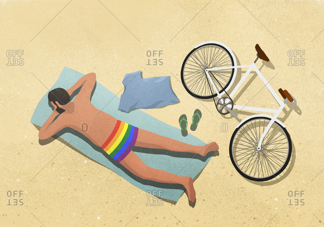 Man in rainbow swim trunks sunbathing on beach towel