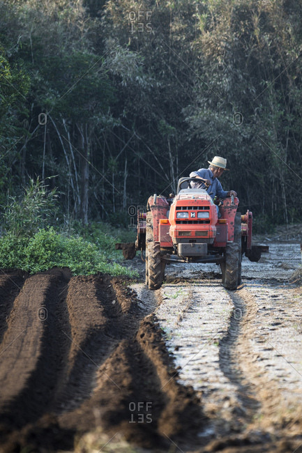 Tahara, Japan - September 16, 2018: Man on tractor working in field