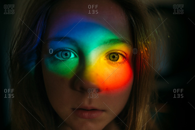 Portrait of a young girl with rainbow glare on her face