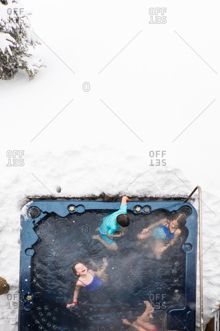 Overhead view of kids in a hot tub outside during winter