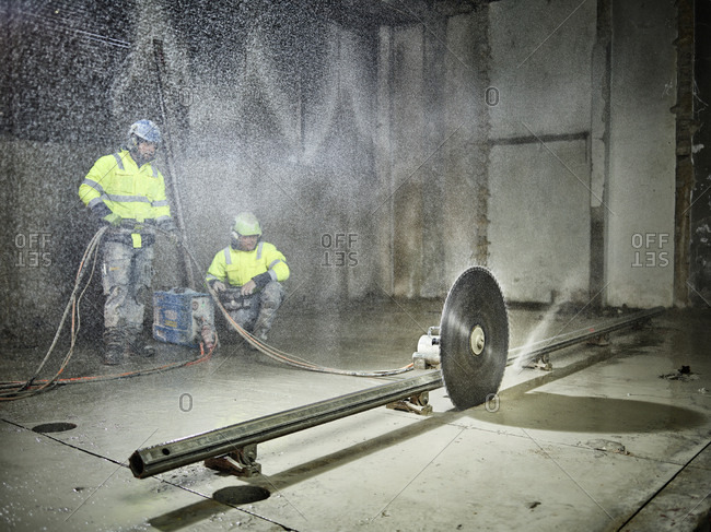 Construction workers sawing with a concrete saw