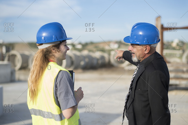 Businessman talking with female worker on industrial site