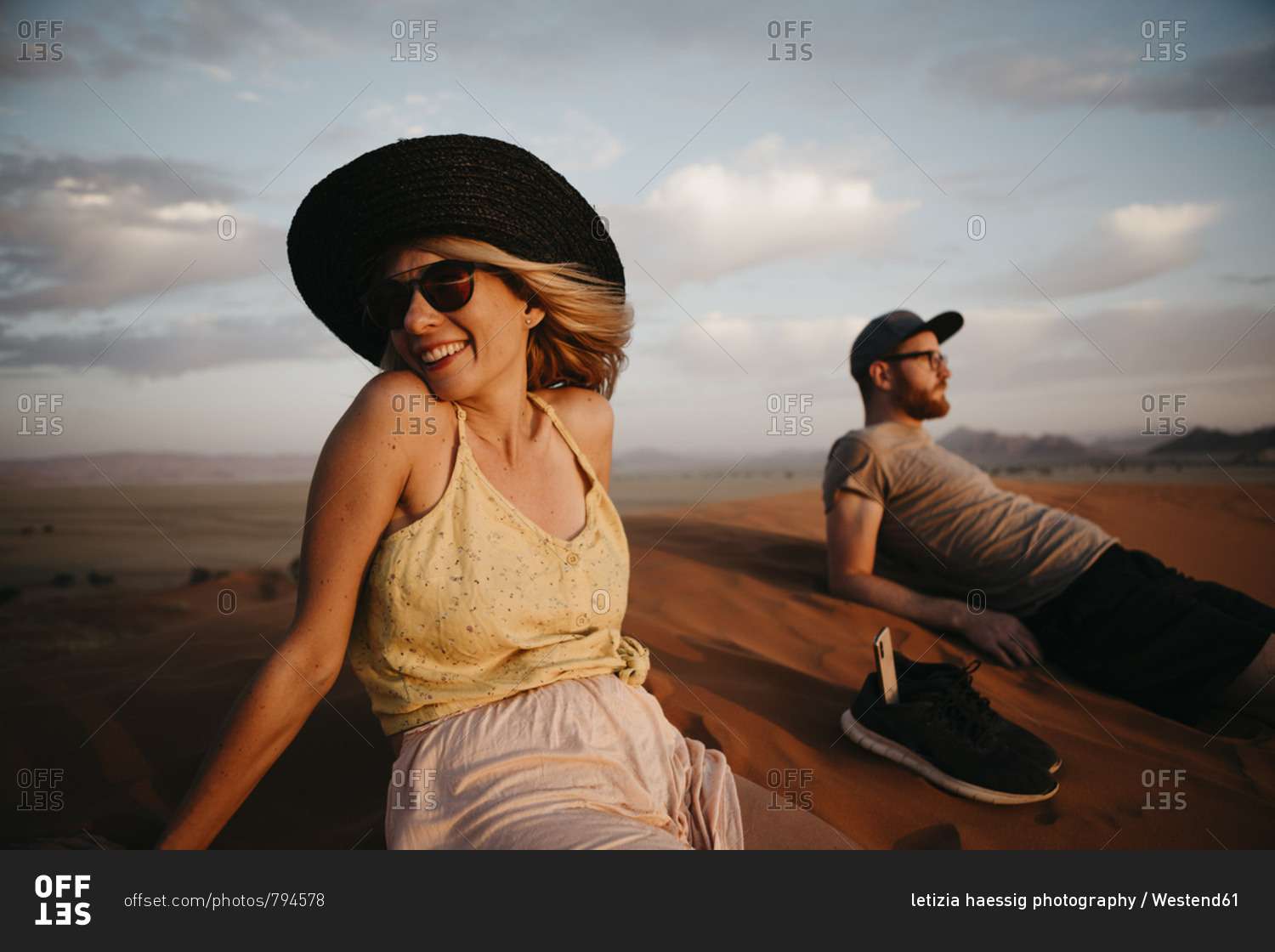 Namibia- Namib desert- Namib-Naukluft National Park- Sossusvlei- happy couple sitting on Elim Dune at sunset