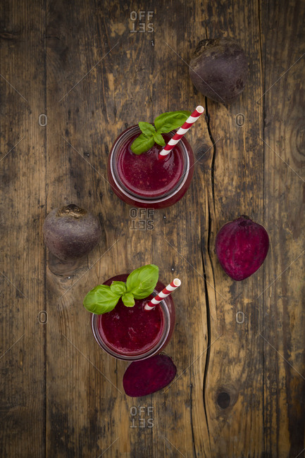 Two glasses of beet root smoothie garnished with basil leaves