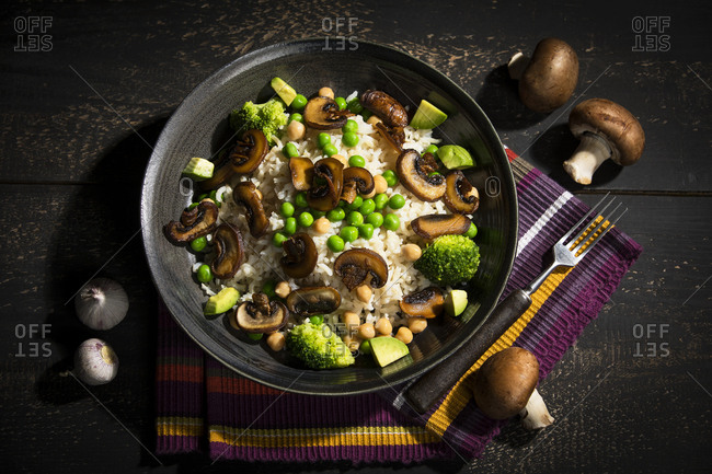 Vegan dish: natural rice with champignons- peas- chick peas- avocado and broccoli