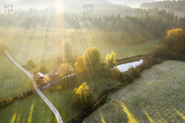 Germany- Bavaria- Aerial view of Kirchseebach river and Pelletsmuehl- sun light and morning fog