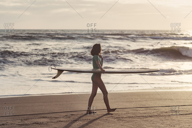 Young woman with surfboard at the beach