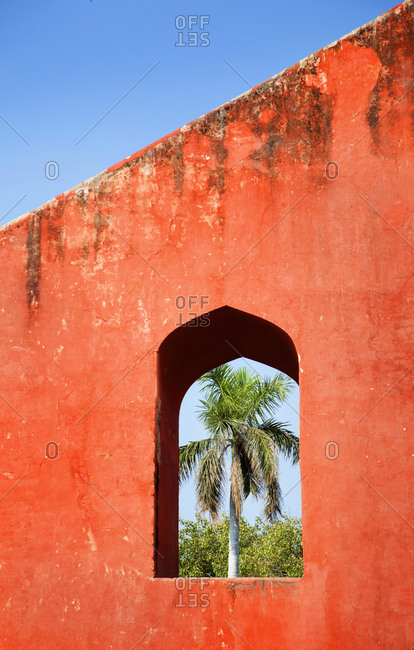 View of a palm tree through red structure at Jantar Mantar Observatory in New Delhi, India
