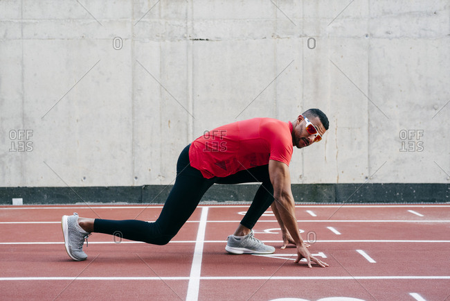 Handsome Ethnic Man Ready In The Starting Position On The Running Track Stock Photo Offset