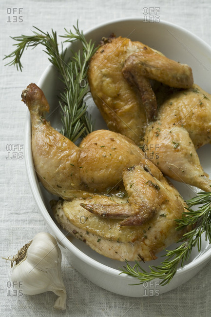 Roasted chicken with garlic and rosemary in oval dish
