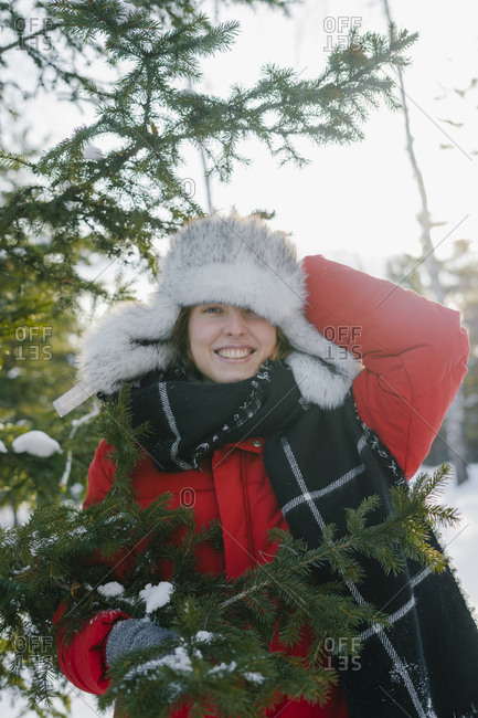 Portrait of a beautiful woman in a fur hat in winter with a smile near the Christmas tree