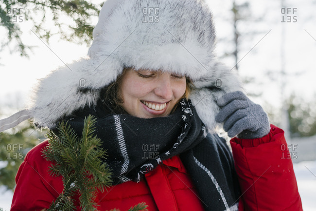 Portrait of a beautiful woman in a fur hat in winter with a smile near the Christmas tree