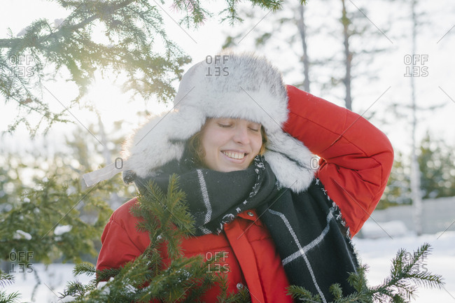 Portrait of a beautiful woman in a fur hat in winter with a smile near the Christmas tree