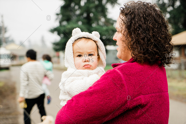 Woman holding baby in fuzzy teddy bear jacket