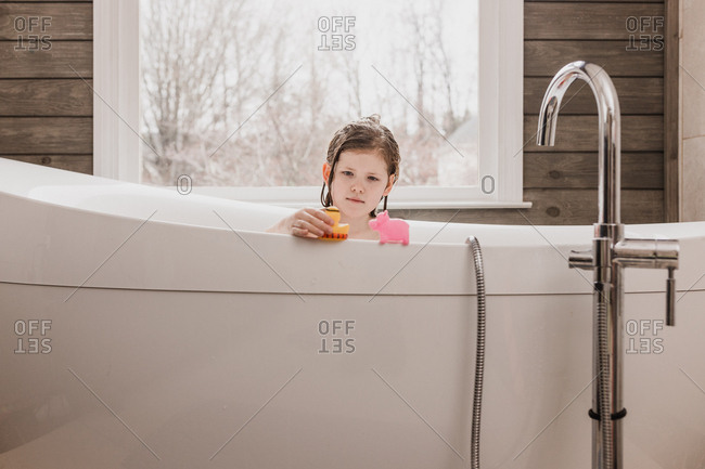 Girl plays with toys during her bath