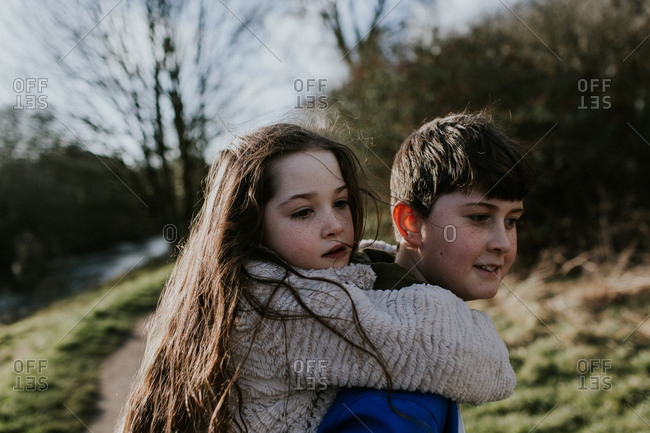 Young girl carrying sister giving piggyback ride Stock Photo