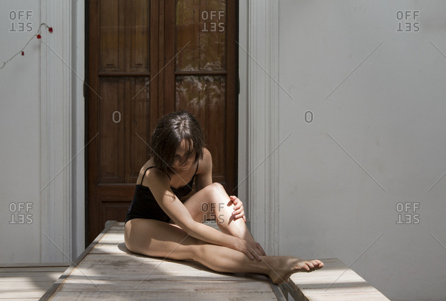 Woman sitting and stretching on outdoor patio