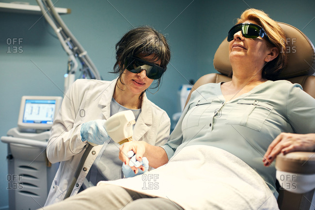 Dermatologist performing an anti-aging laser procedure on a patient's hand