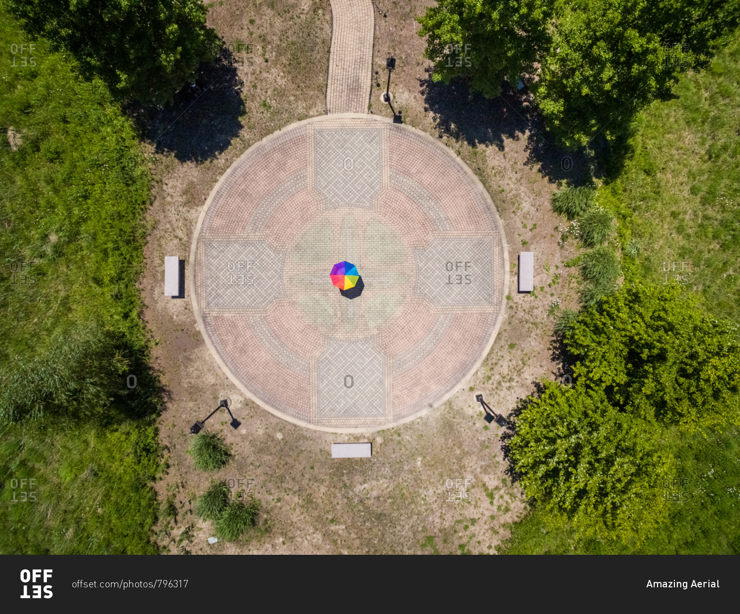 Aerial view of person holding colorful umbrella on pebble background, USA.
