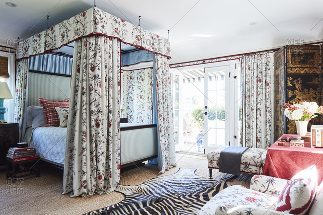 Los Angeles, California - October 5, 2016: Bedroom with floral wallpaper and canopy around bed that opens to patio