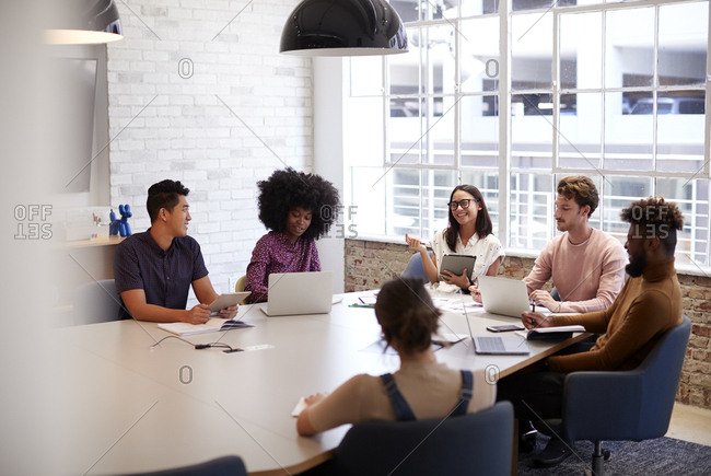Millennial creative coworkers in discussion in an office meeting room, selective focus