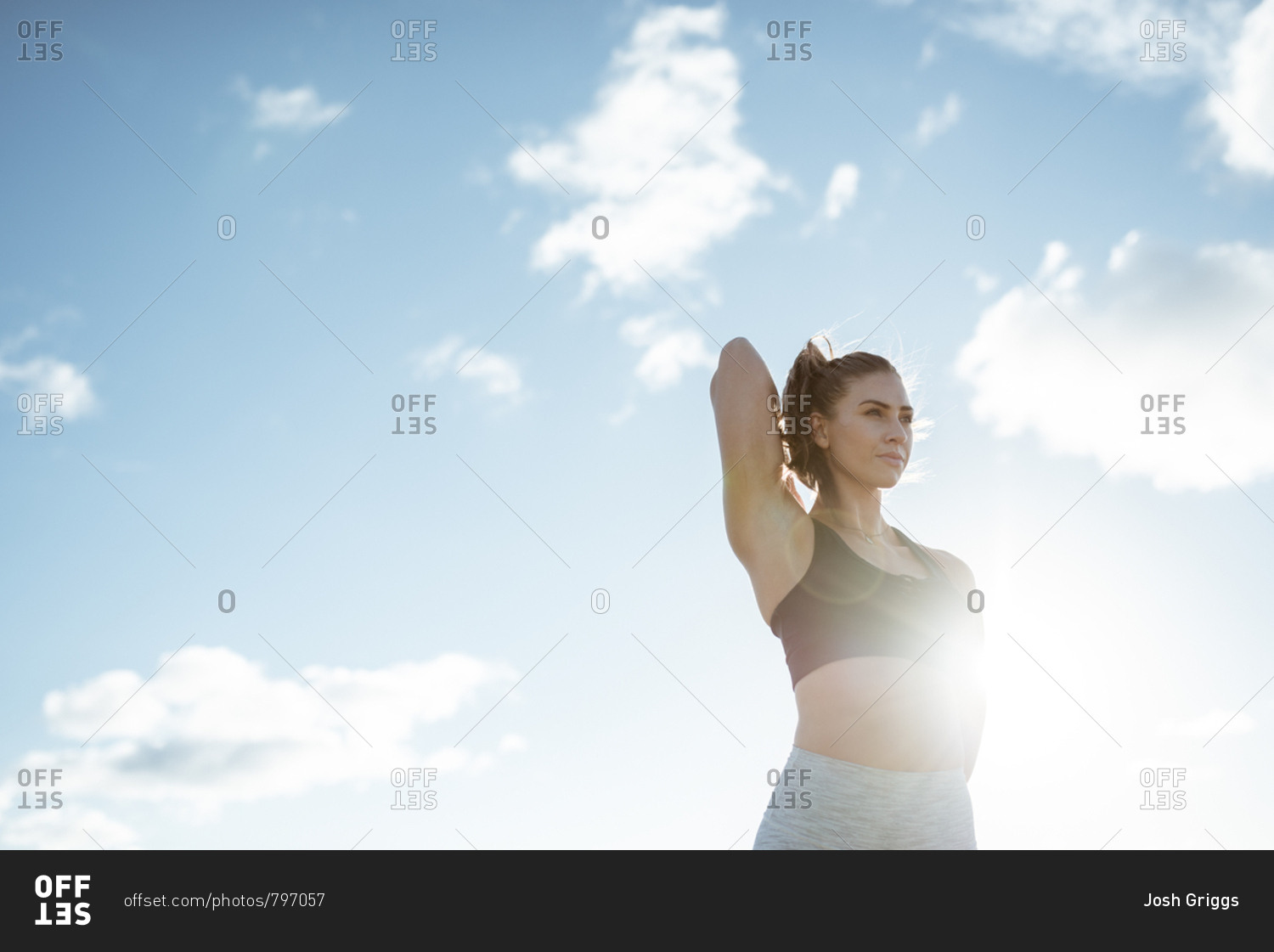 Low angle view of woman stretching her arms before workout in the countryside