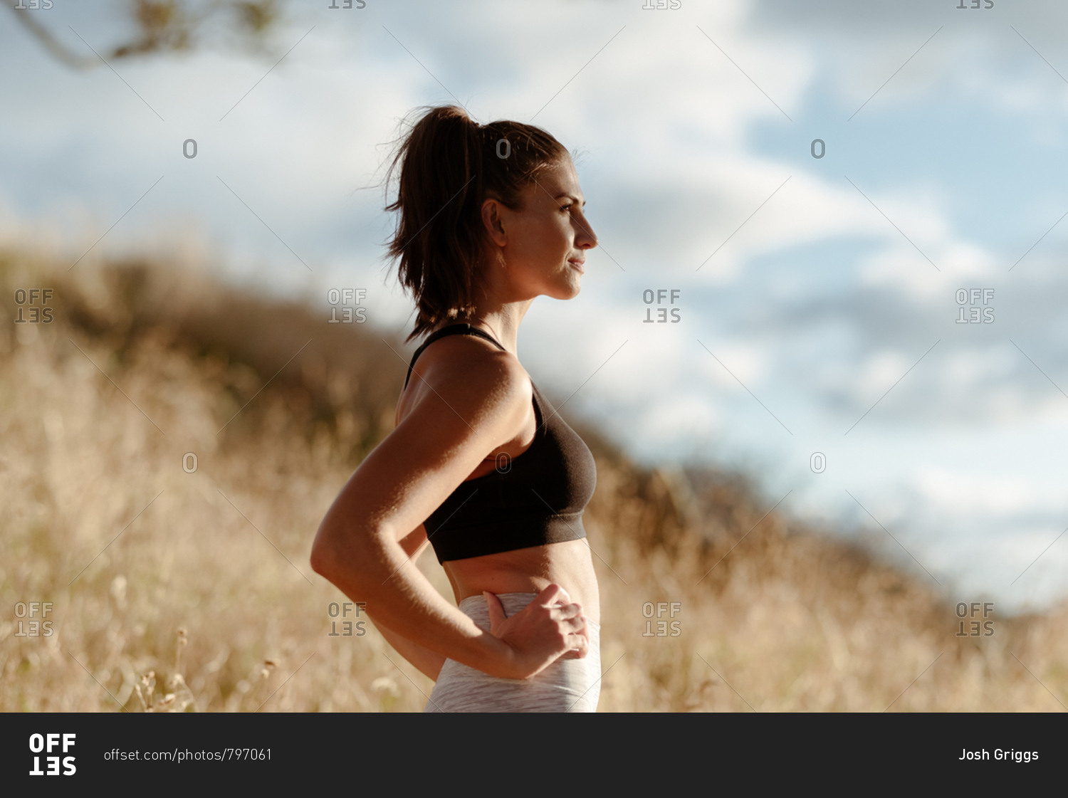 Profile view of young woman in workout clothes in the country