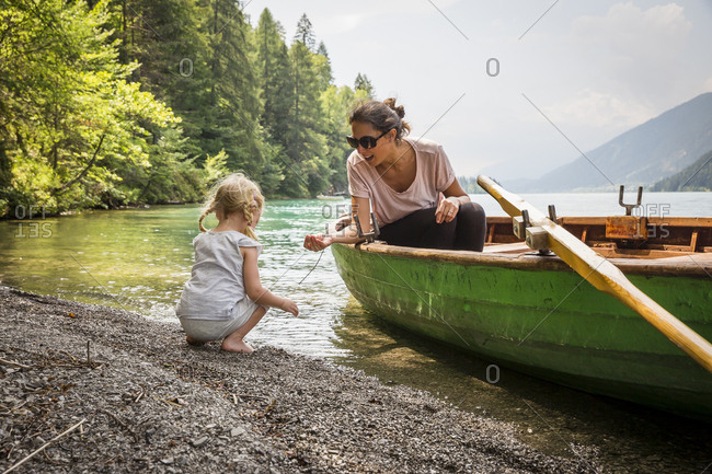 Austria- Carinthia- Weissensee- mother in rowing boat with daughter at the lakeside
