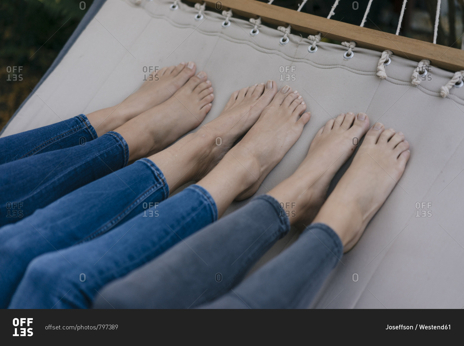 Feet of three females lying in hammock in garden