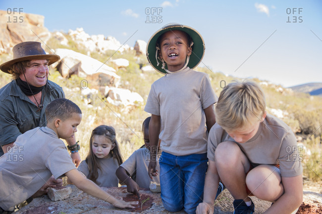 Children at a camp learning from guide