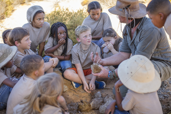 Children at a camp learning from guide