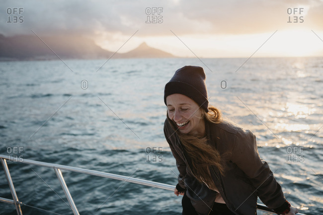 South Africa- young woman with woolly hat during boat trip at sunset