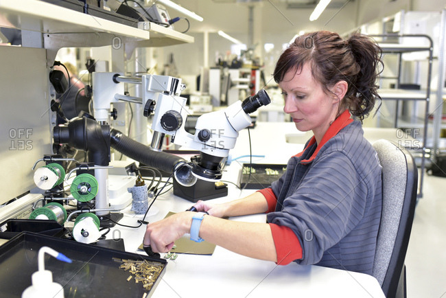 Woman working on quality control in the manufacturing of circuit boards for the electronics industry