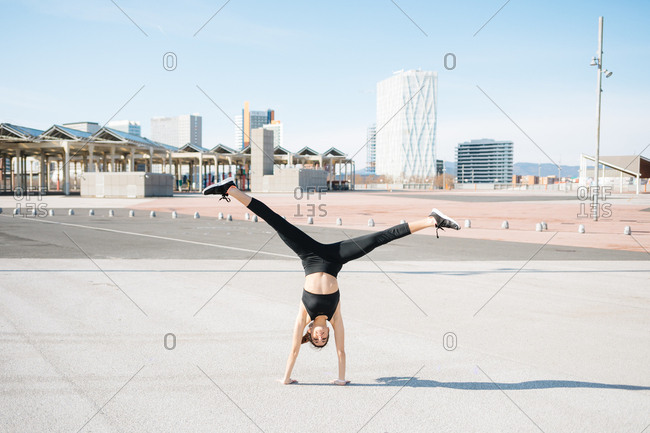 Young woman head stand with legs open