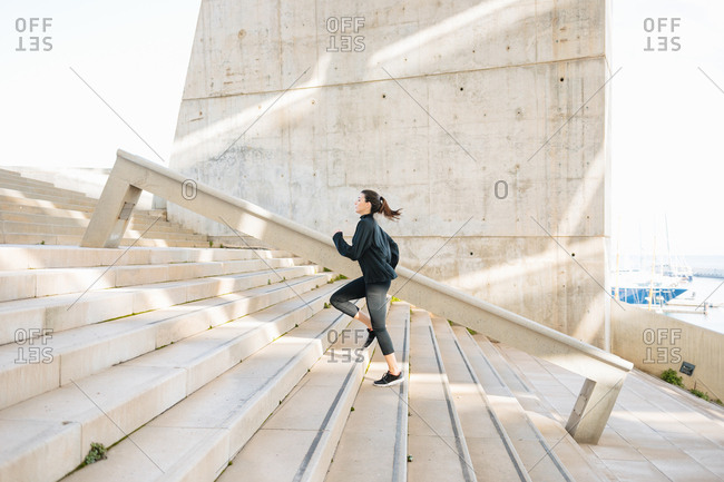 Young athlete running, warming up, climbing stairs