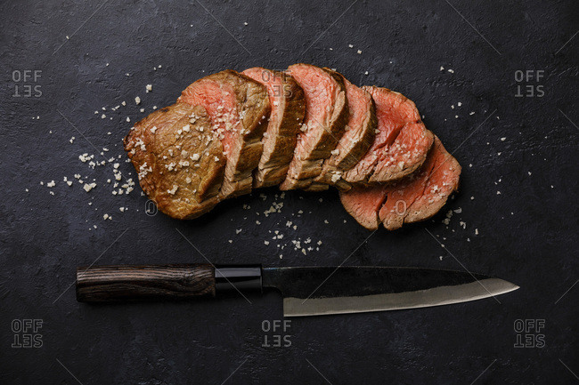 Sliced grilled meat barbecue Steak and kitchen Knife on black background