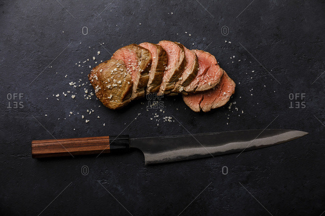Sliced grilled meat barbecue Steak and kitchen Knife on black background